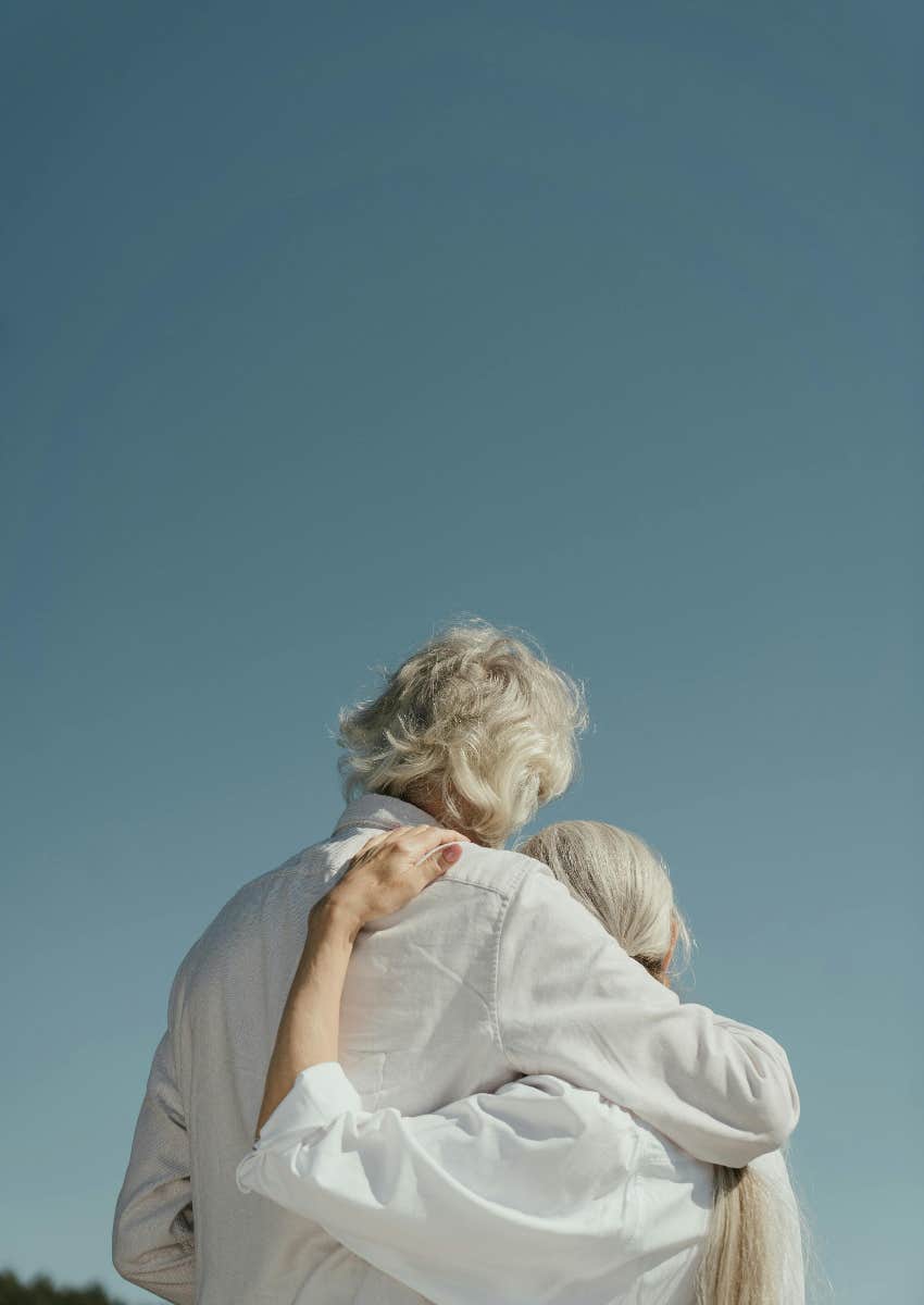 elderly couple with their arms around each other