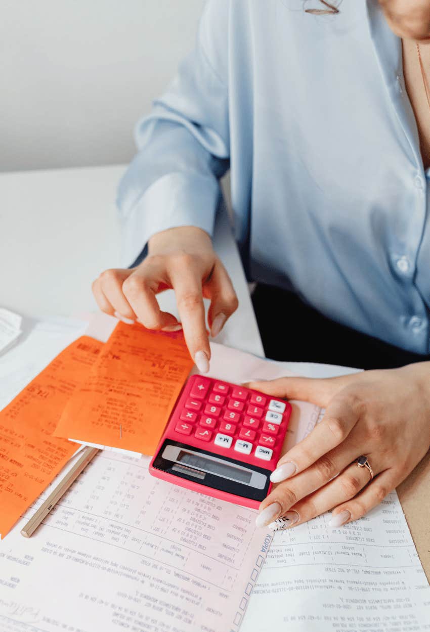 woman using calculator and faced with financial reality