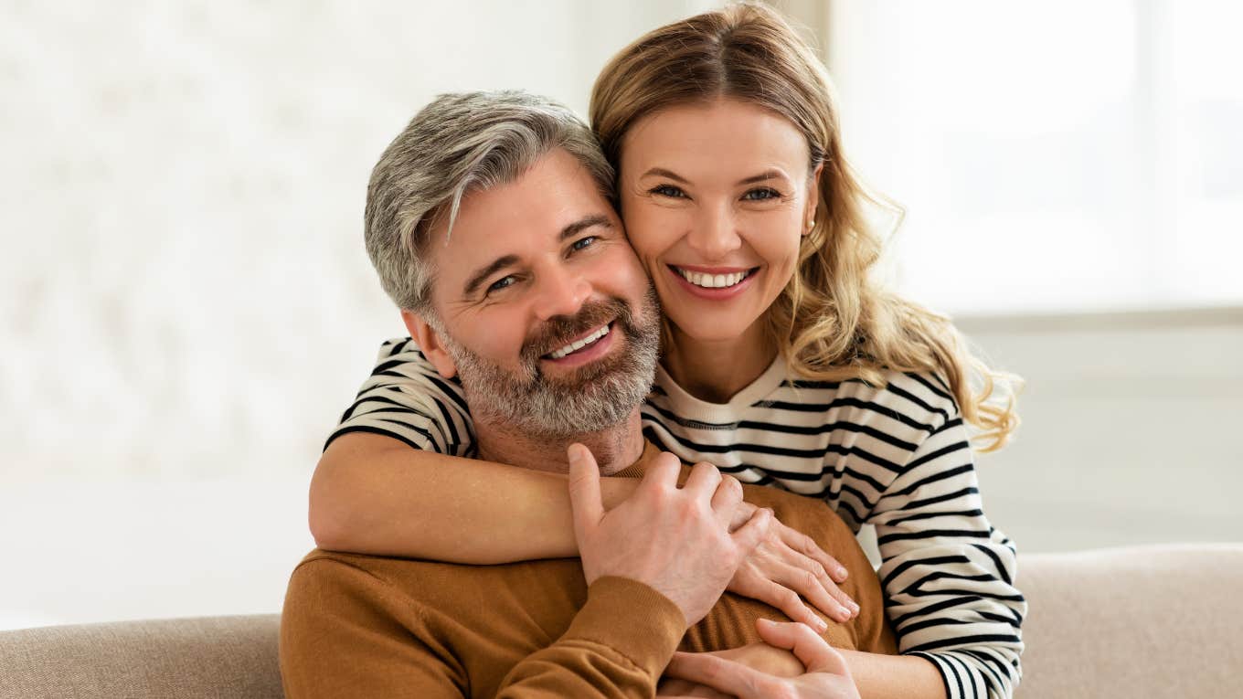 Women Typically Find Men With These Personality Traits The Most Attractive woman hugging man from behind lovingly