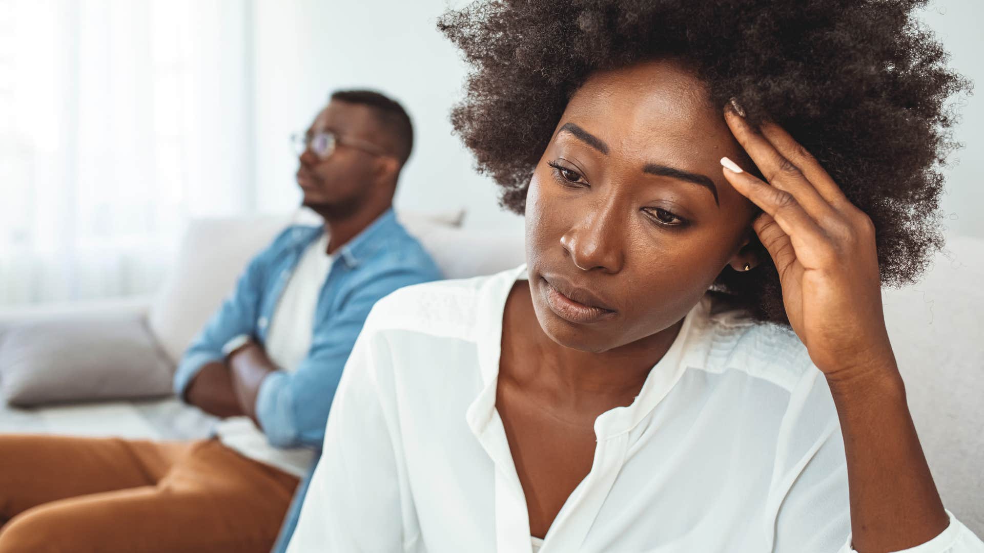 sad woman turned away from her husband thinking about double standards