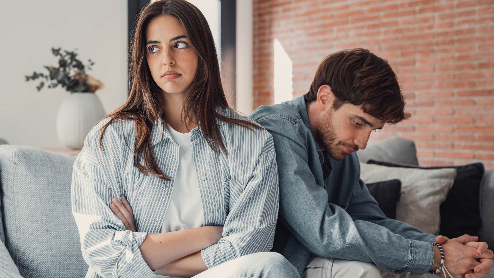 couple who's grown apart sitting on the couch together