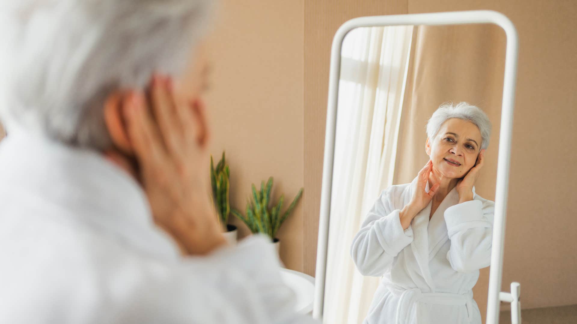 happy older woman looking in the mirror