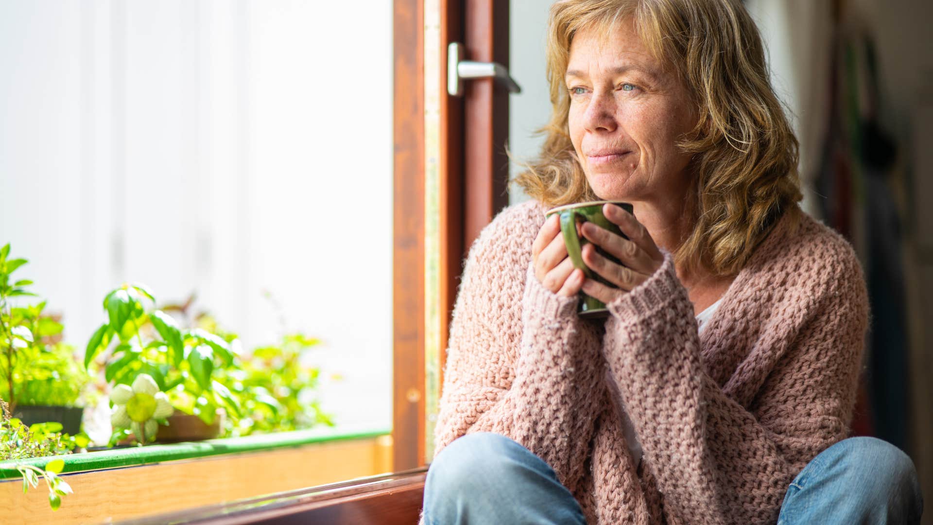 older woman drinking out of mug after trusting intuition