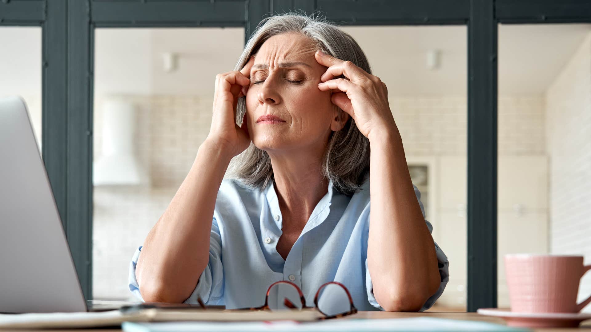 older woman stressed from carrying emotional labor