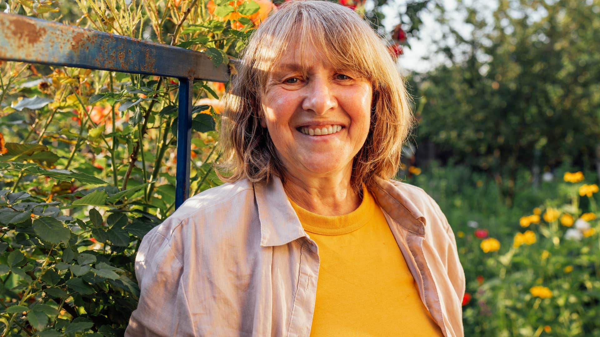 older woman who's tired of people-pleasing smiling