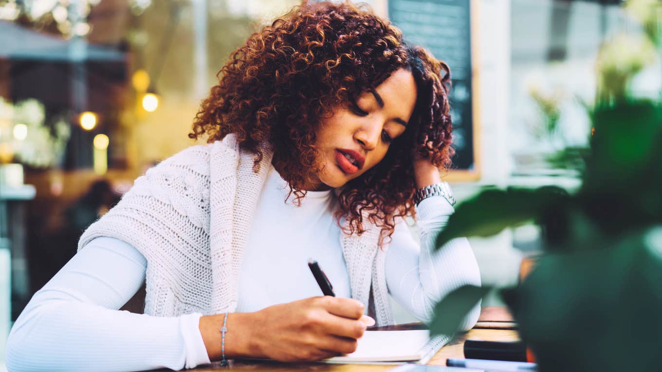 If you still write things down in a physical planner instead of your phone, experts say you display these rare traits Woman writing in physical planner.