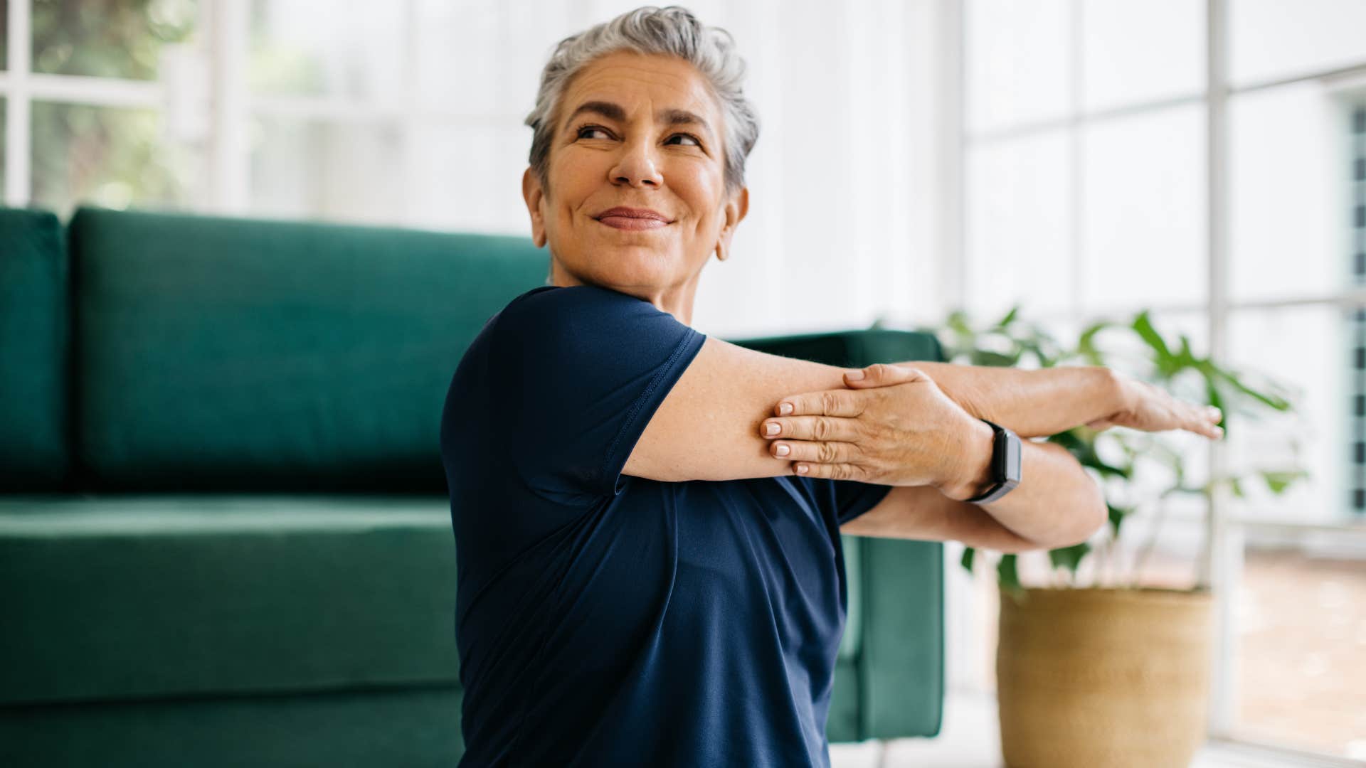 an older woman exercises in her home like she used to do as a kid
