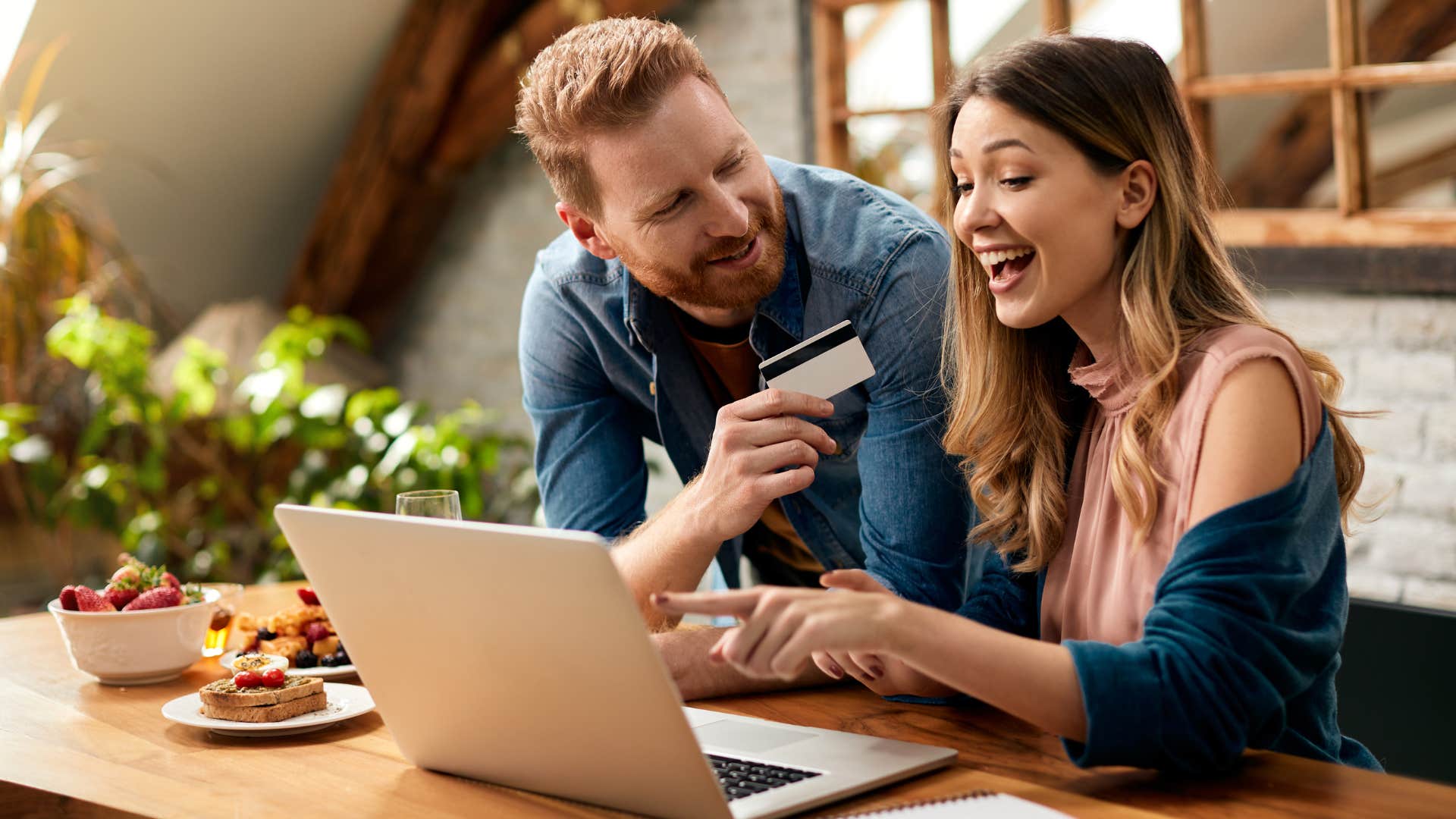 Couple smiling and spending money without checking their bank account.