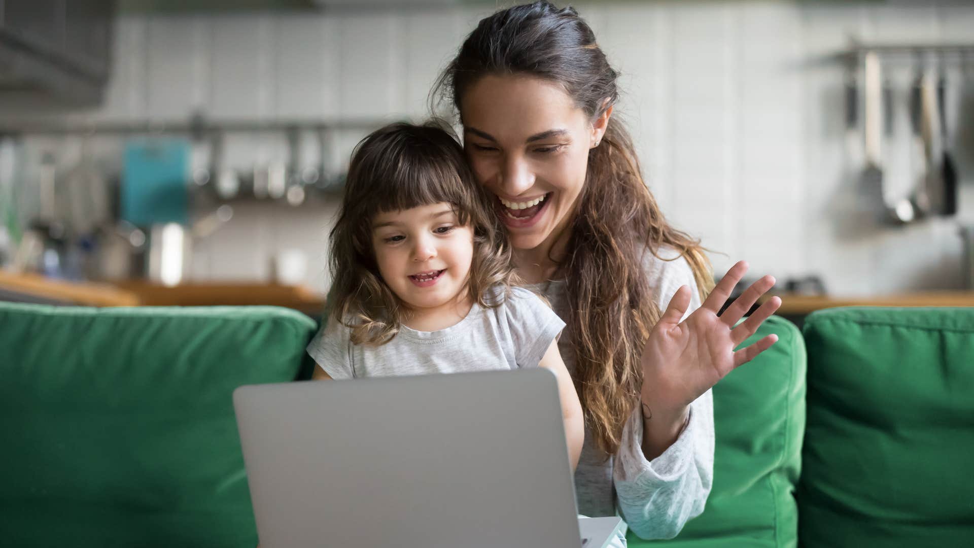 mother on her laptop with daughter in her lap