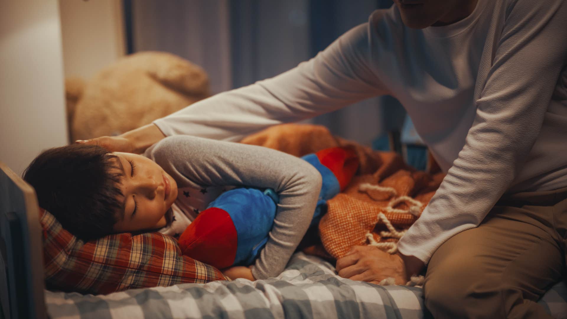 father tucking in his child for bed