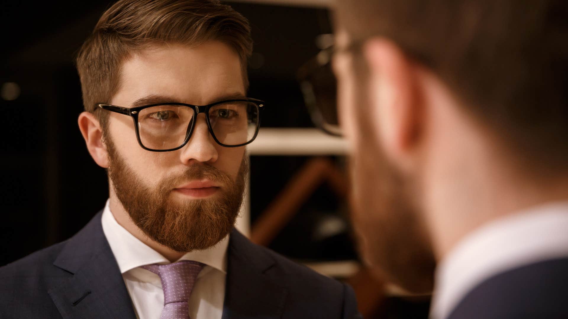 serious man looking at himself in mirror