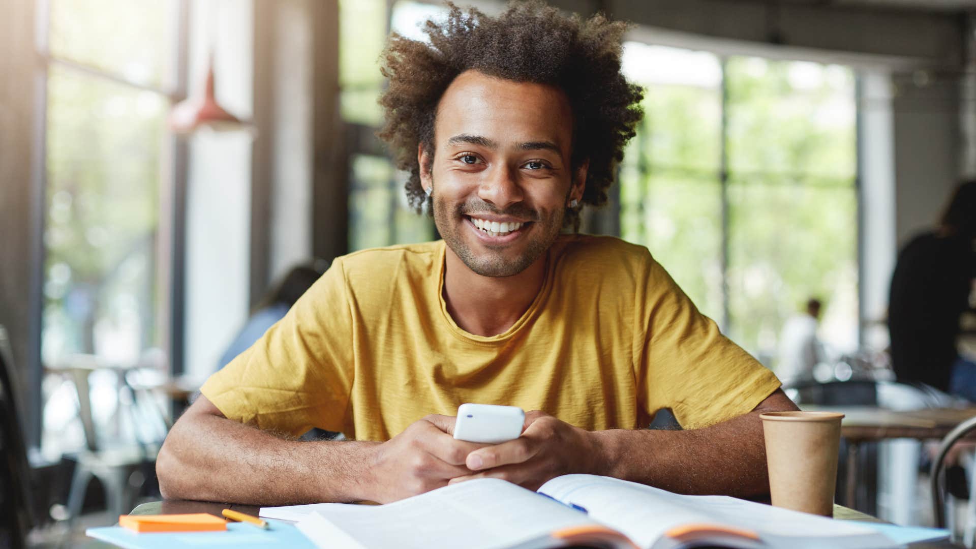 smiling man working towards his passions in a cafe