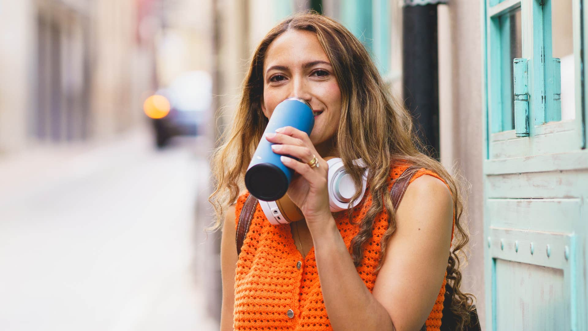 woman drinking out of reusable water bottle