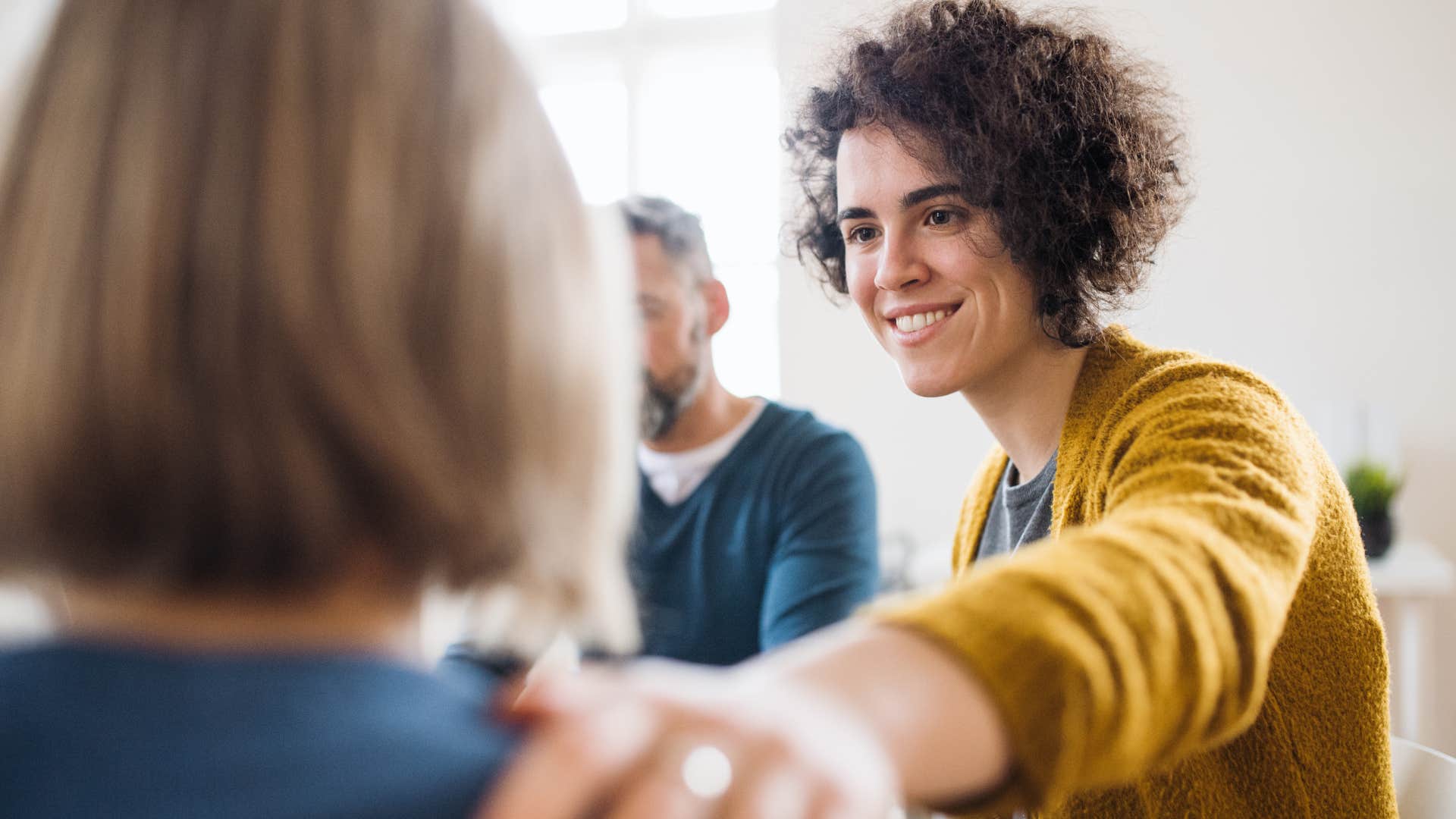 woman putting her hand on a friend's shoulder and saying I'm just brutally honest