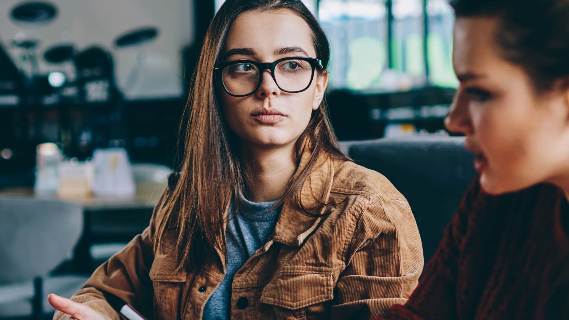 annoyed woman saying don't be so negative to a friend