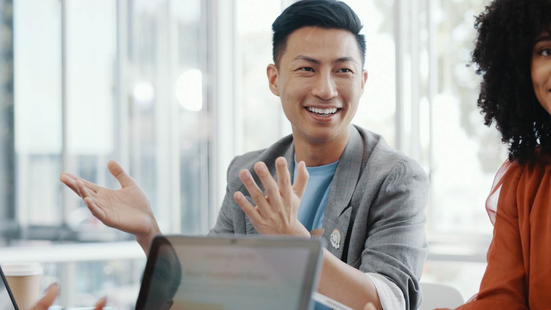 unbothered man shrugging and saying sorry not sorry to co-workers
