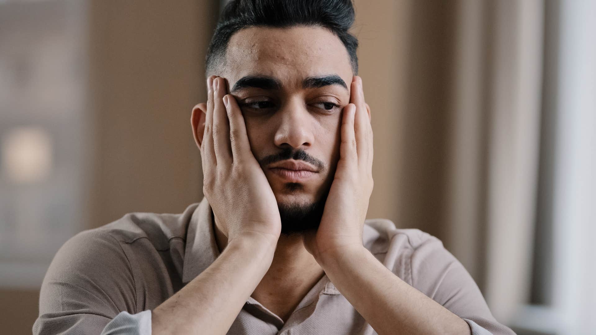 sad man with his head in his hands thinking