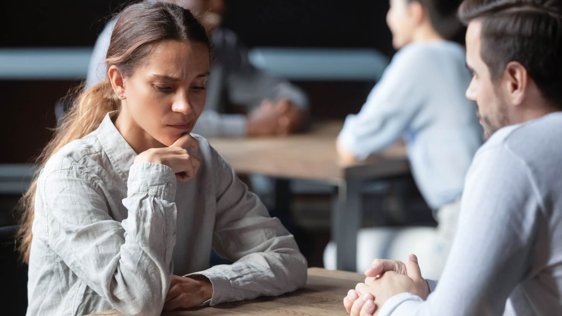 Nervous woman saying "I'm terrible at small talk" to a man.