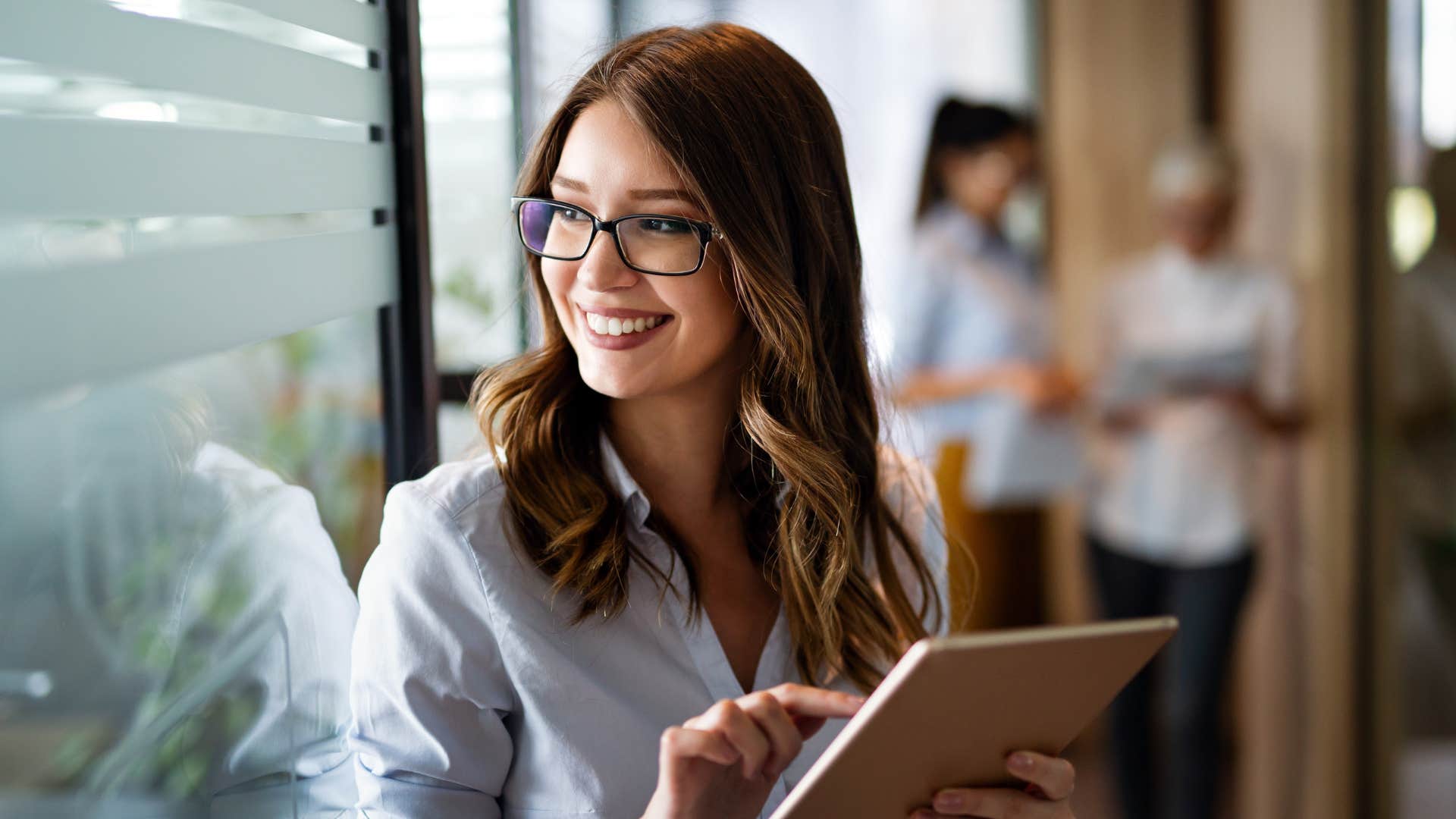 woman in glasses being hyper independent as she is on ipad
