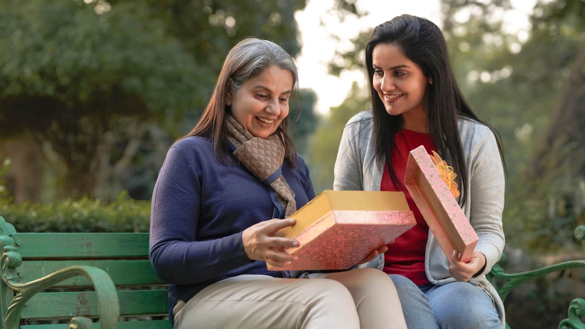 young woman giving surprise gift to older woman