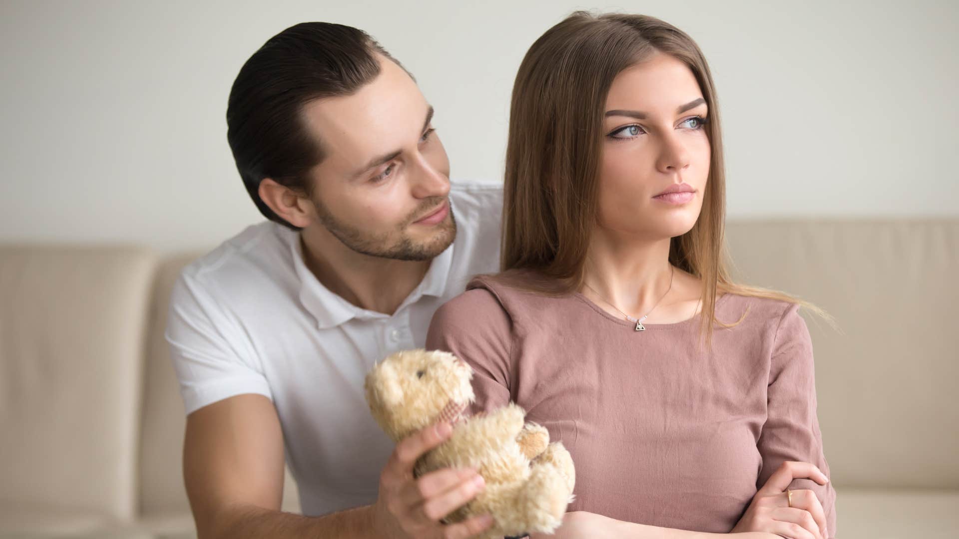 a man gives his girlfriend a gift even though she has checked out of the relationship