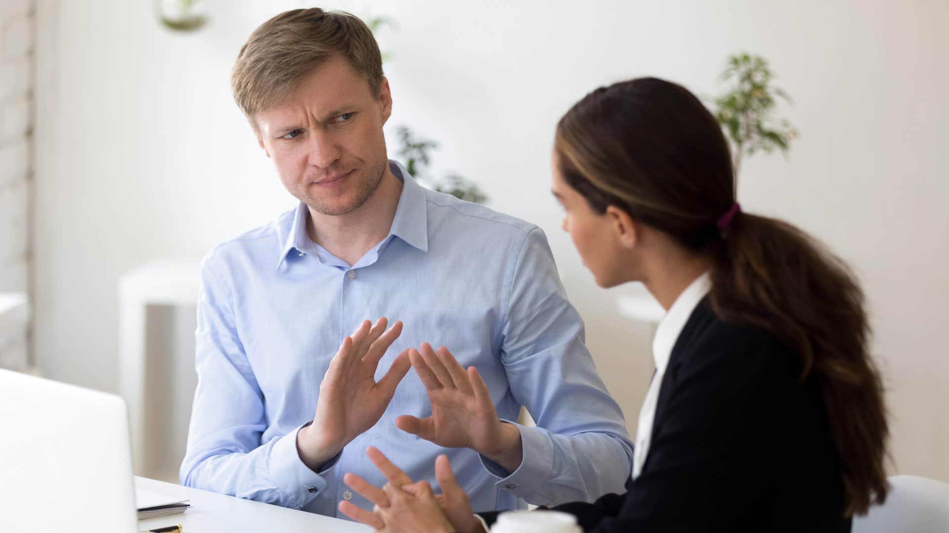 a man tries to tell her female coworker to stop flattering him