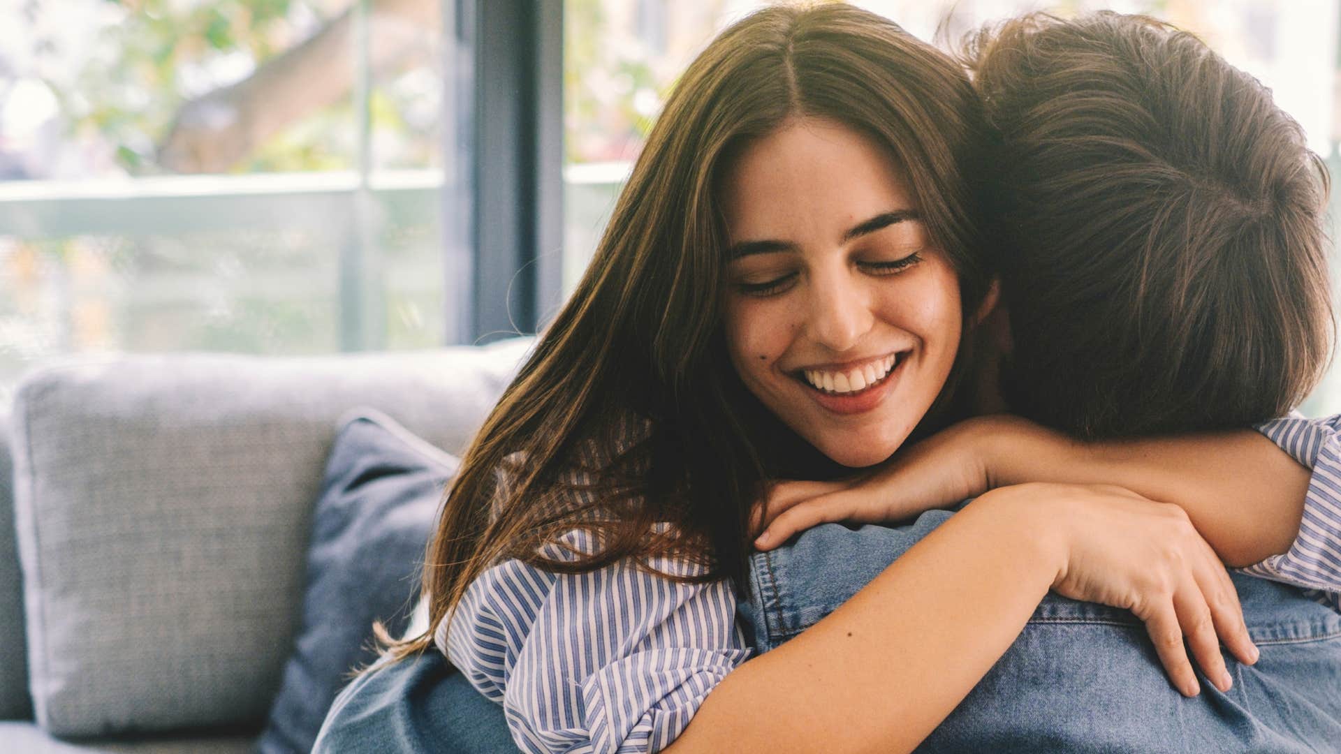 happy young woman expressing gratitude hugging partner