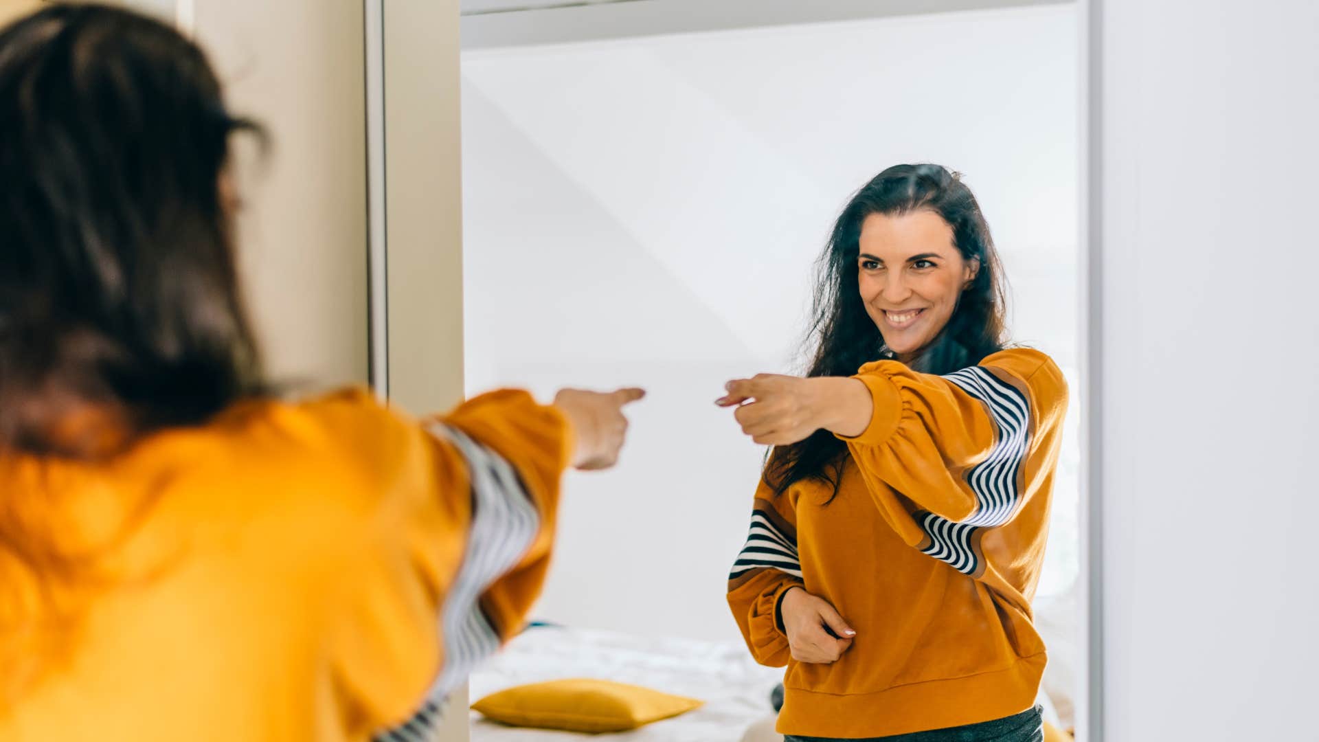 woman talking to herself positively in the mirror