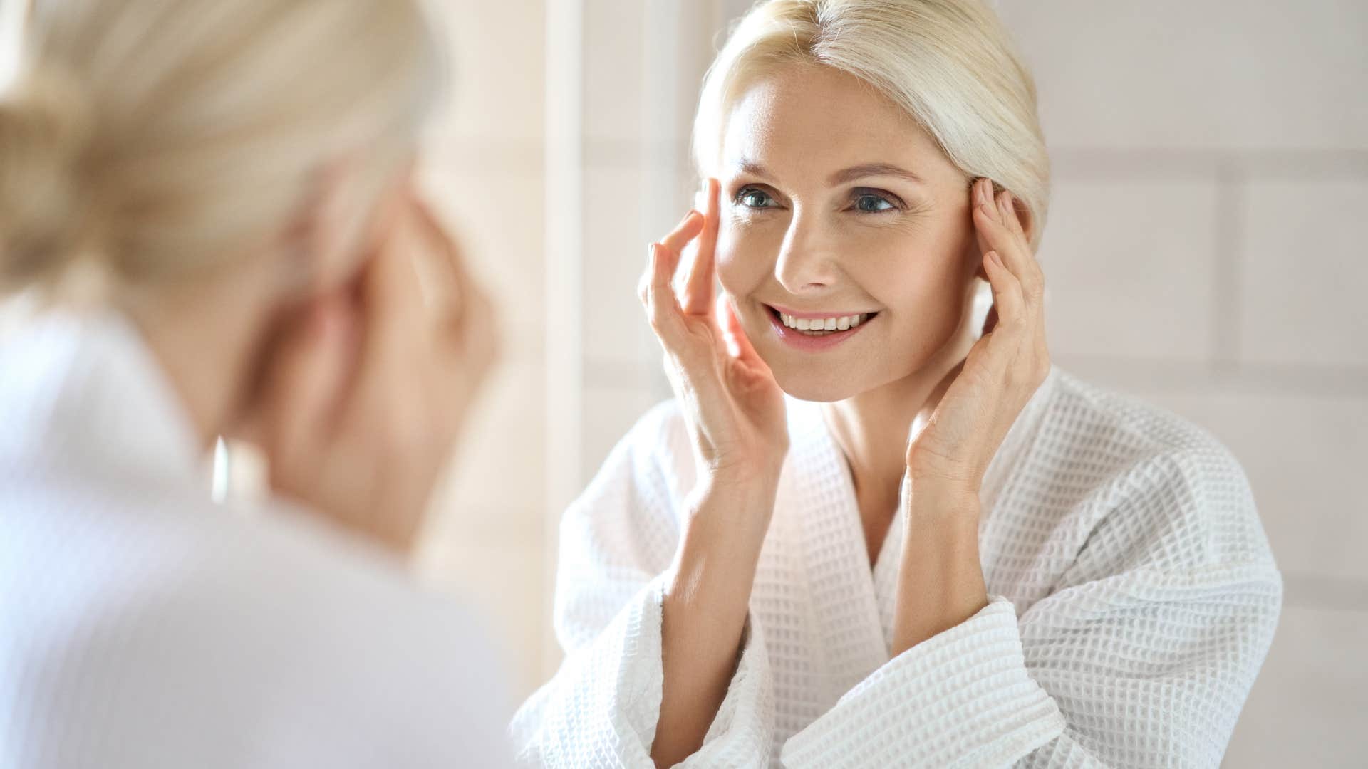 woman who refuses to let age define her as she smiles in mirror