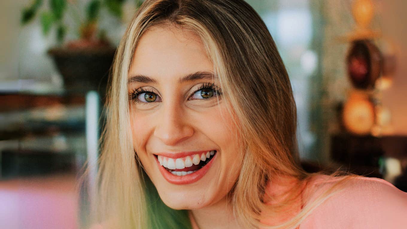 Easy Ways To Feel A Tiny Bit Happier Each Day, According To Psychology Person feeling happy.