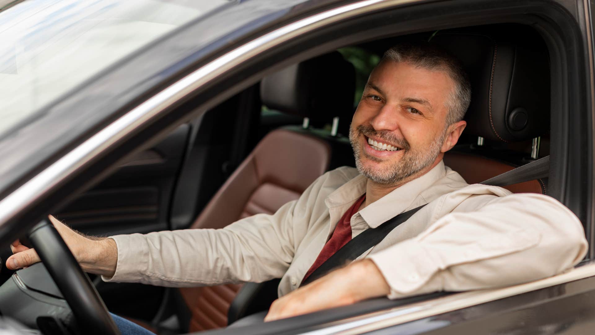 Man buying a new car and smiling.