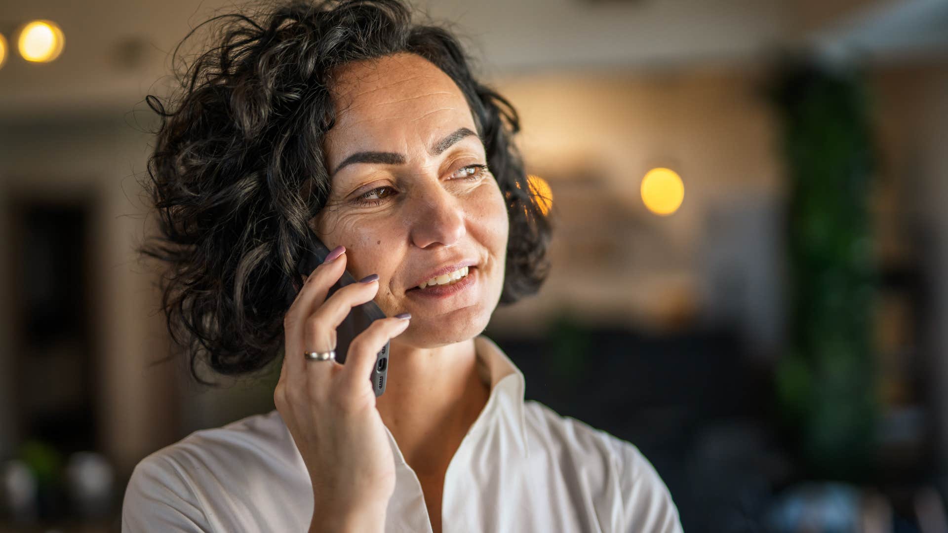 Woman leaving voicemails on her phone at home.