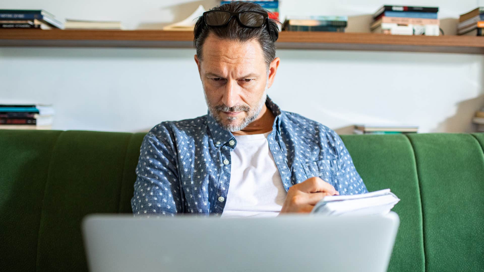 Man taking notes on paper at home.