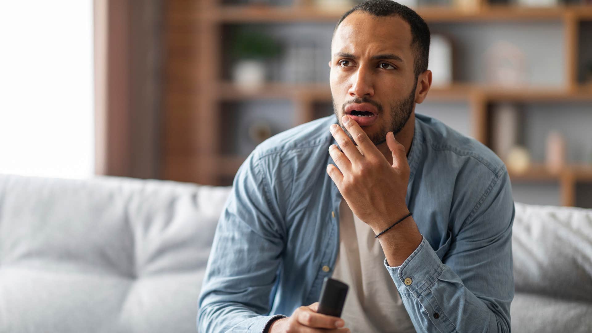 confused man sitting on couch