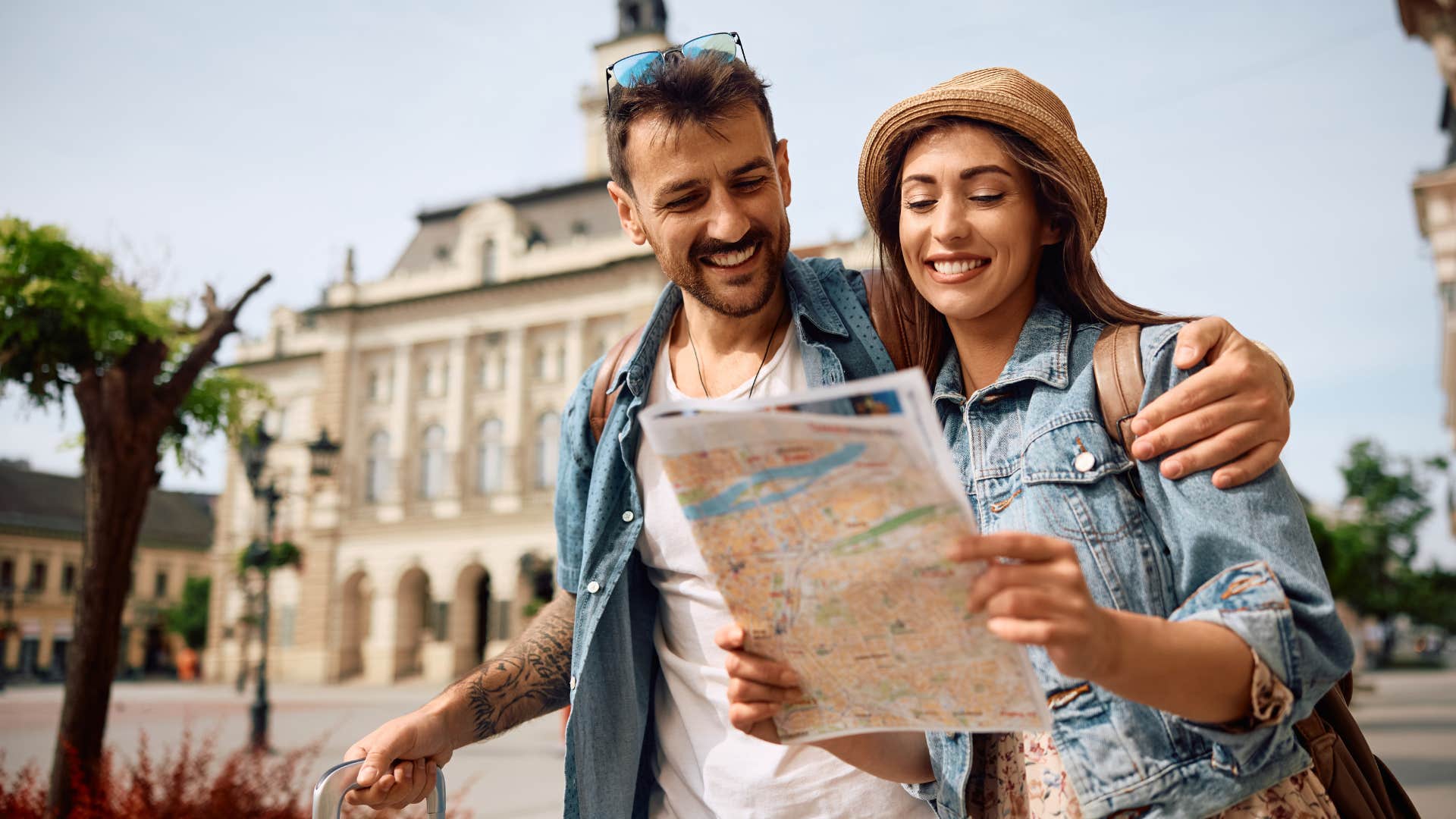 couple traveling together as they look at map and figure out where to get mementos at