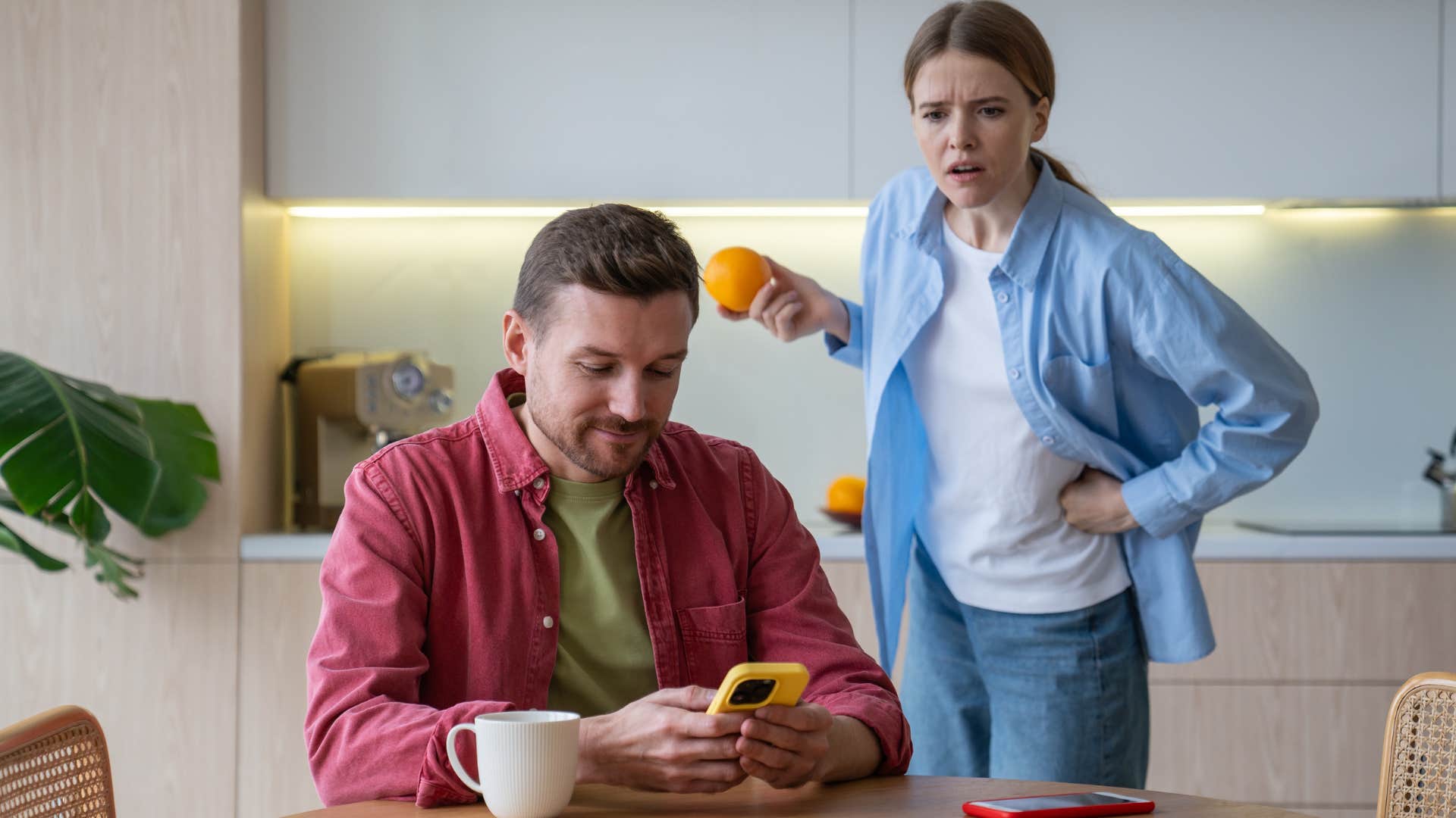 man glued to his phone ignoring concerned wife