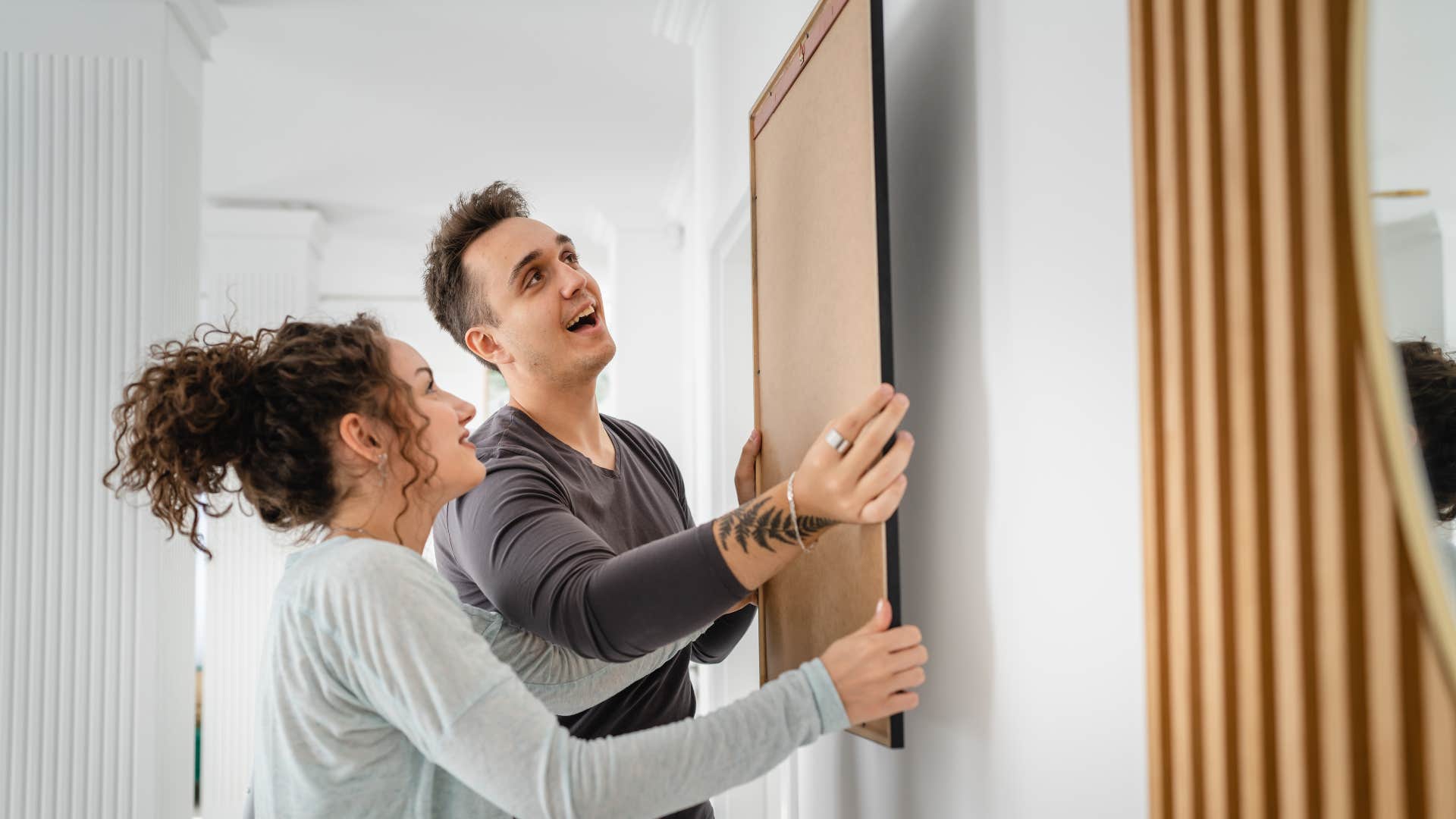 couple putting up decor together in their home