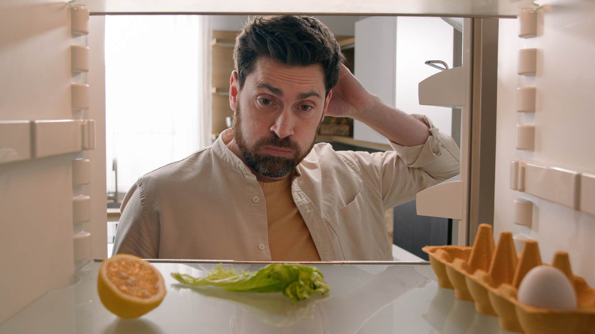 man looking in fridge for something to eat
