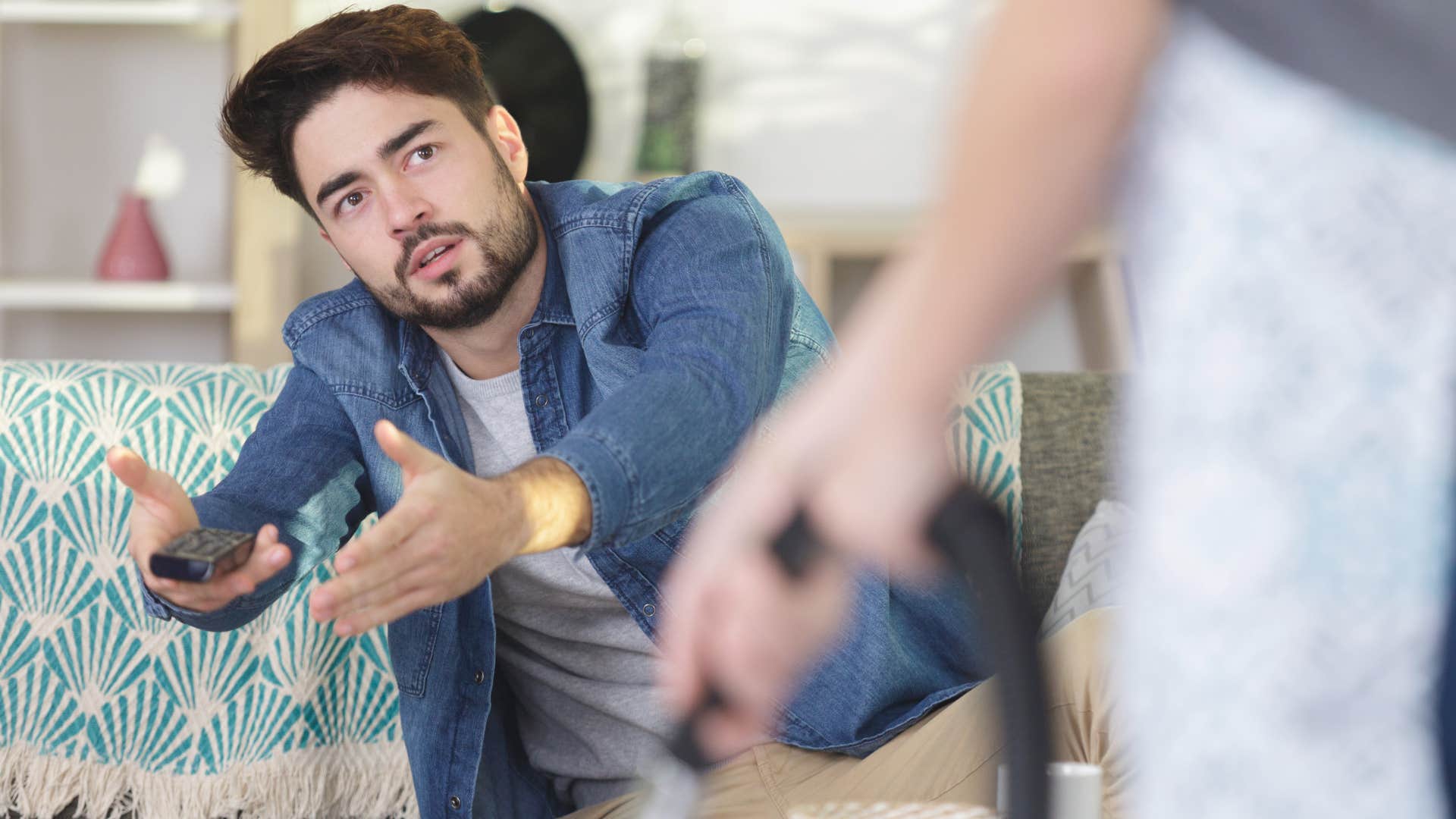 Woman standing in front of her husband who's stopped helping with chores and responsibilities.