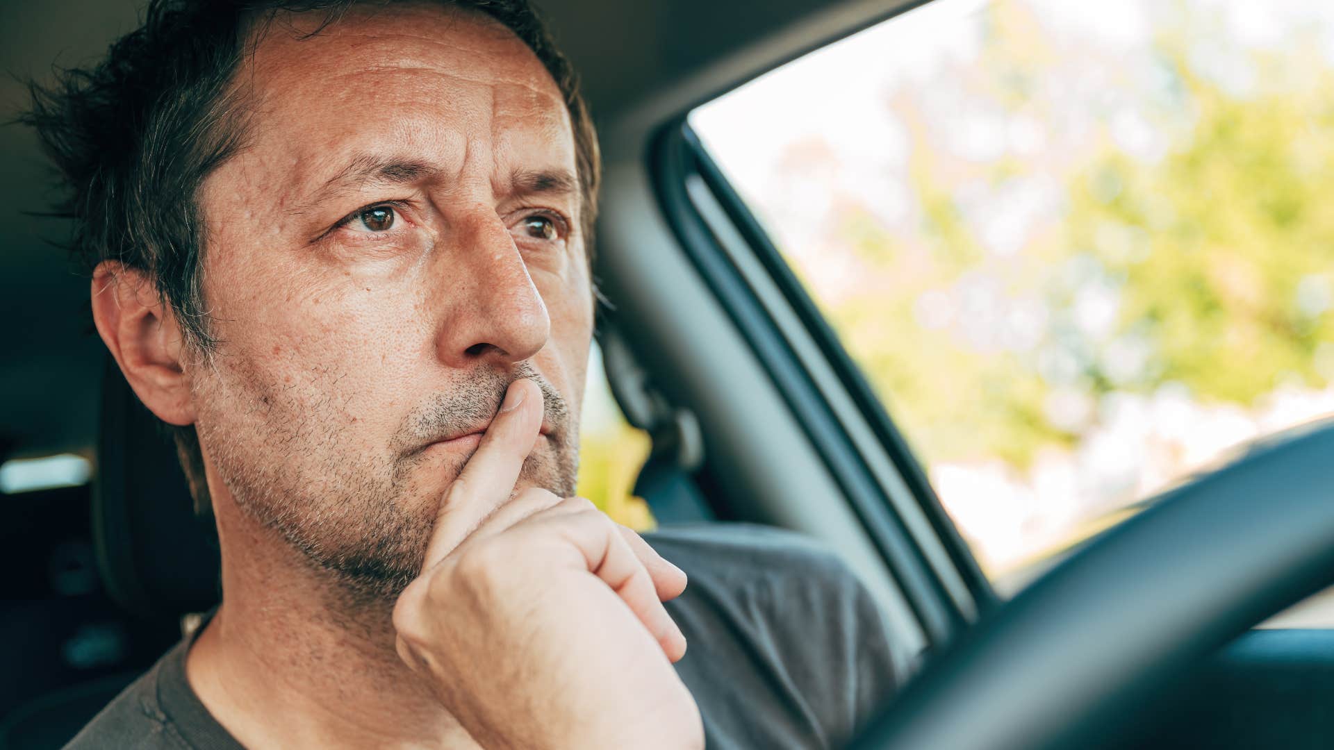 Man who starts going out more sitting in his car.