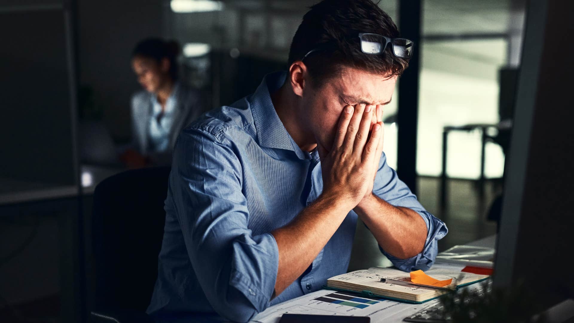 Man who stays at work longer looking at his computer.