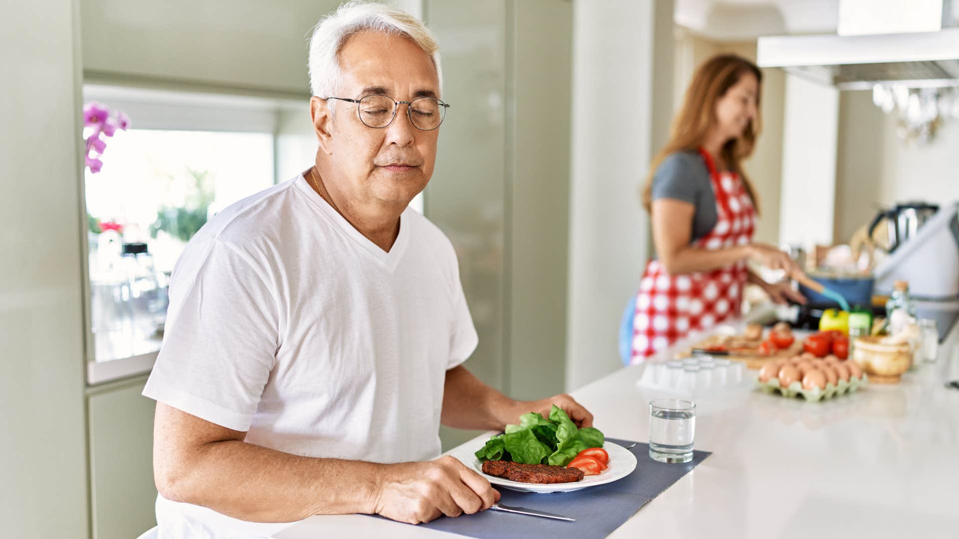 man avoiding eye contact sitting near his wife in the kitchen