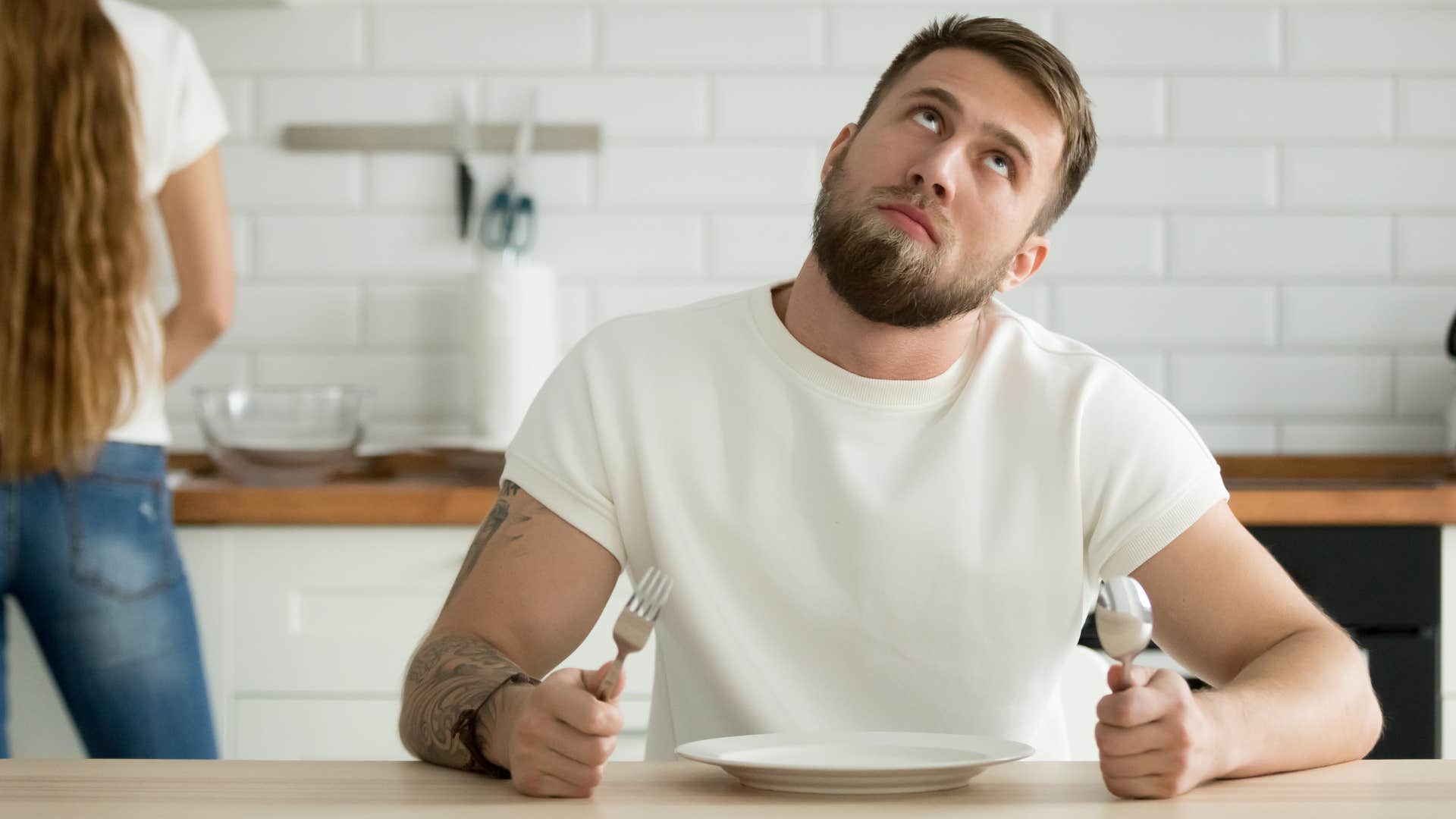 lazy man who doesn't offer to help or make food sitting in the kitchen
