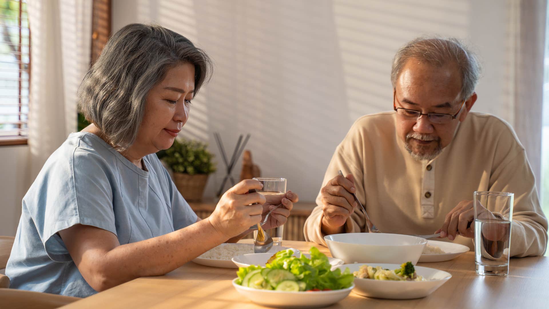 man giving one-word answers eating with his wife