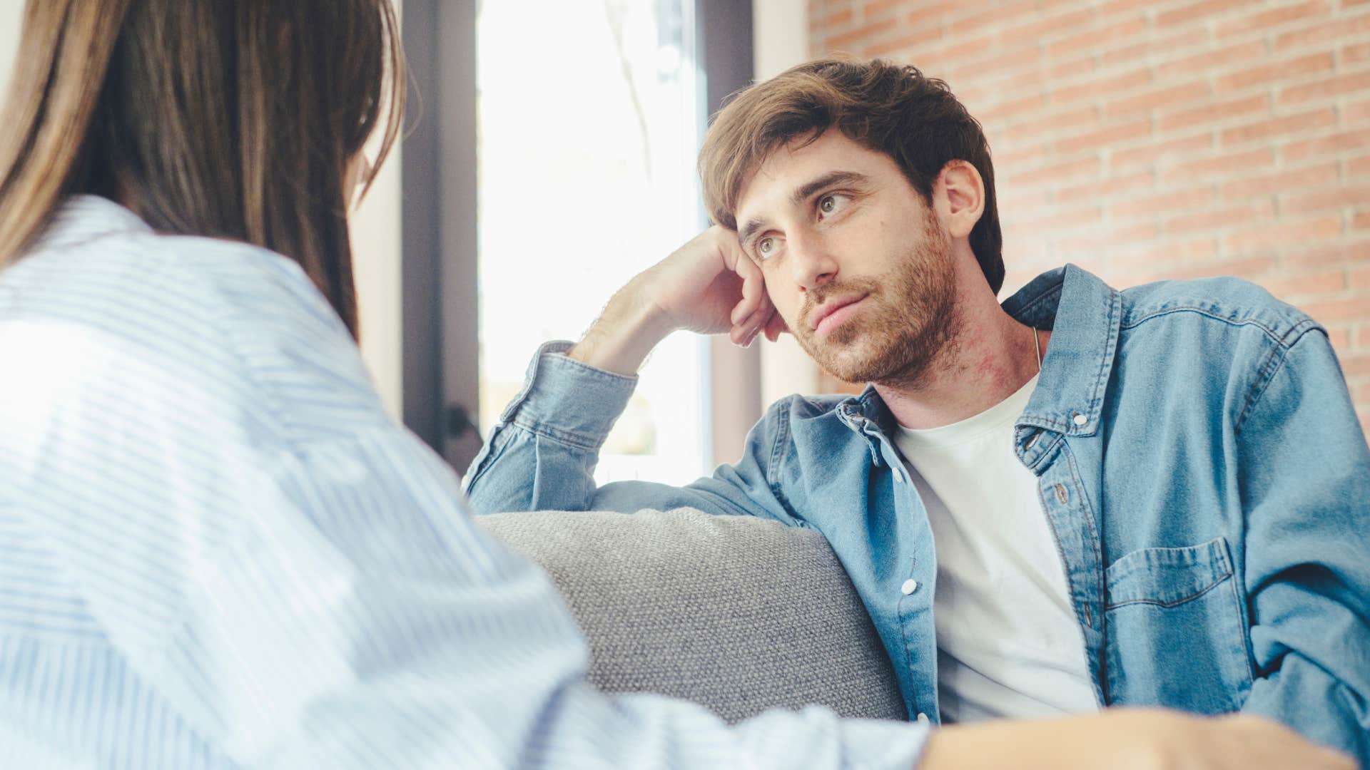 Upset man saying "I'm sorry" to his wife.