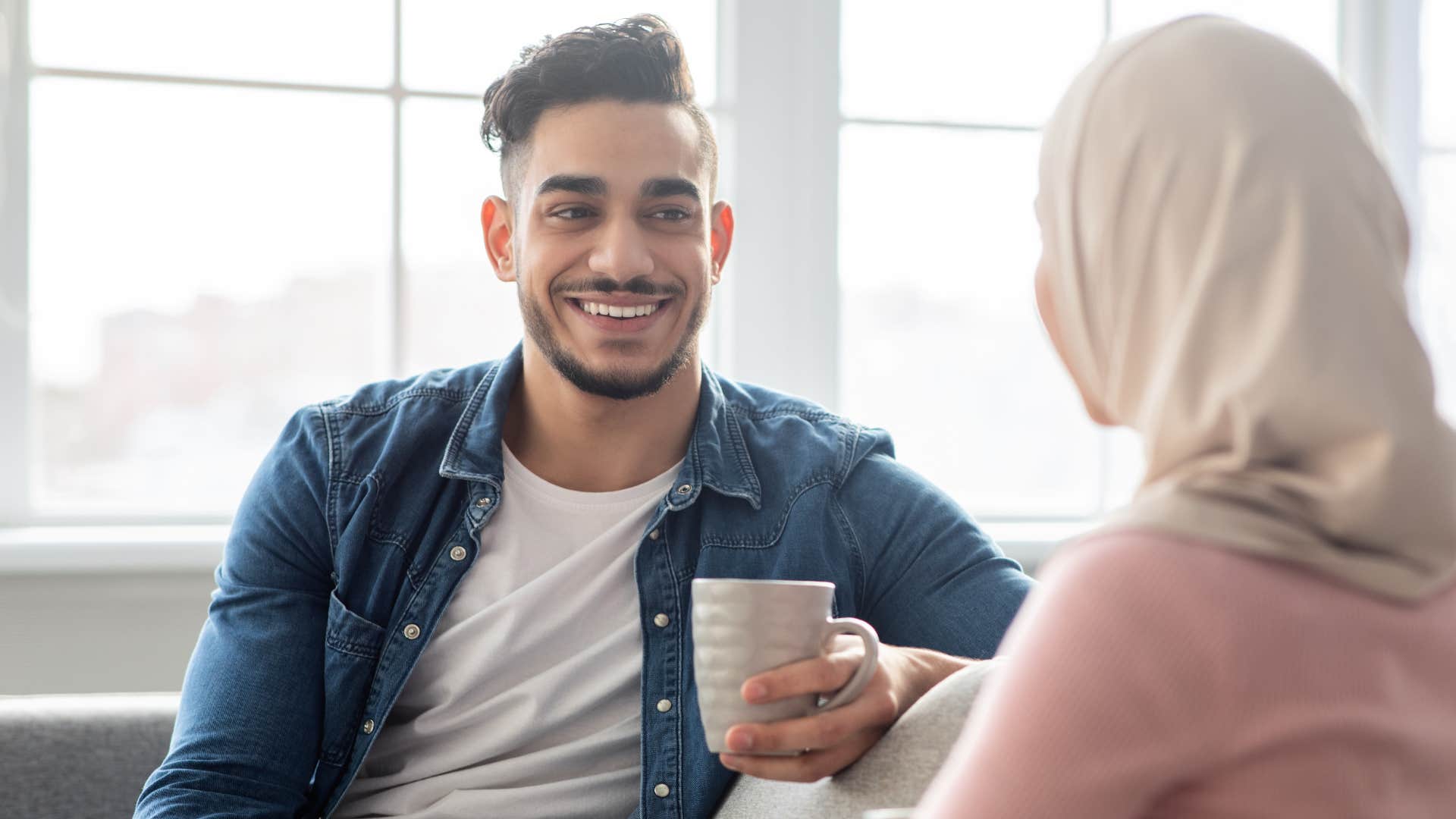 Man saying "tell me more" to his partner.