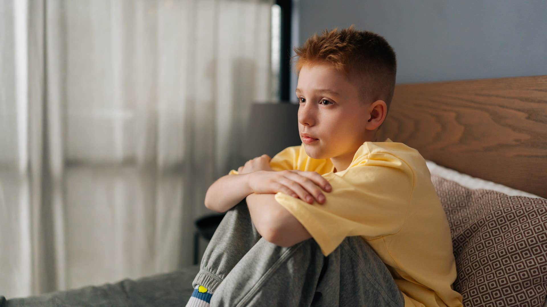 young boy sitting in room alone