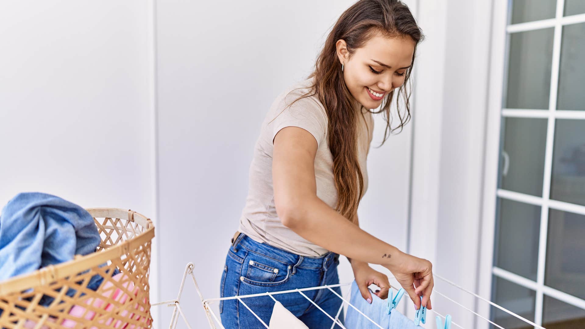 frugal woman hanging her wet laundry on a clothesline