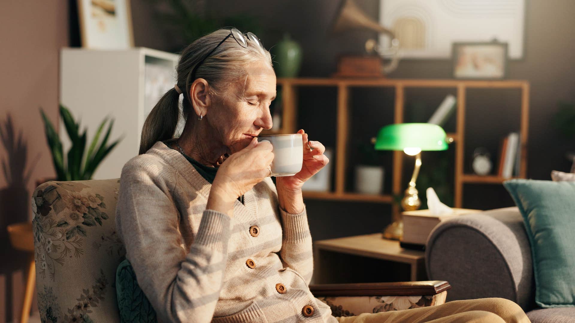 frugal older woman sitting on worn furniture