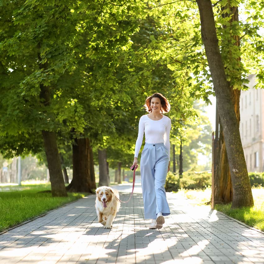 woman who is a delightful person as she takes dog for a walk